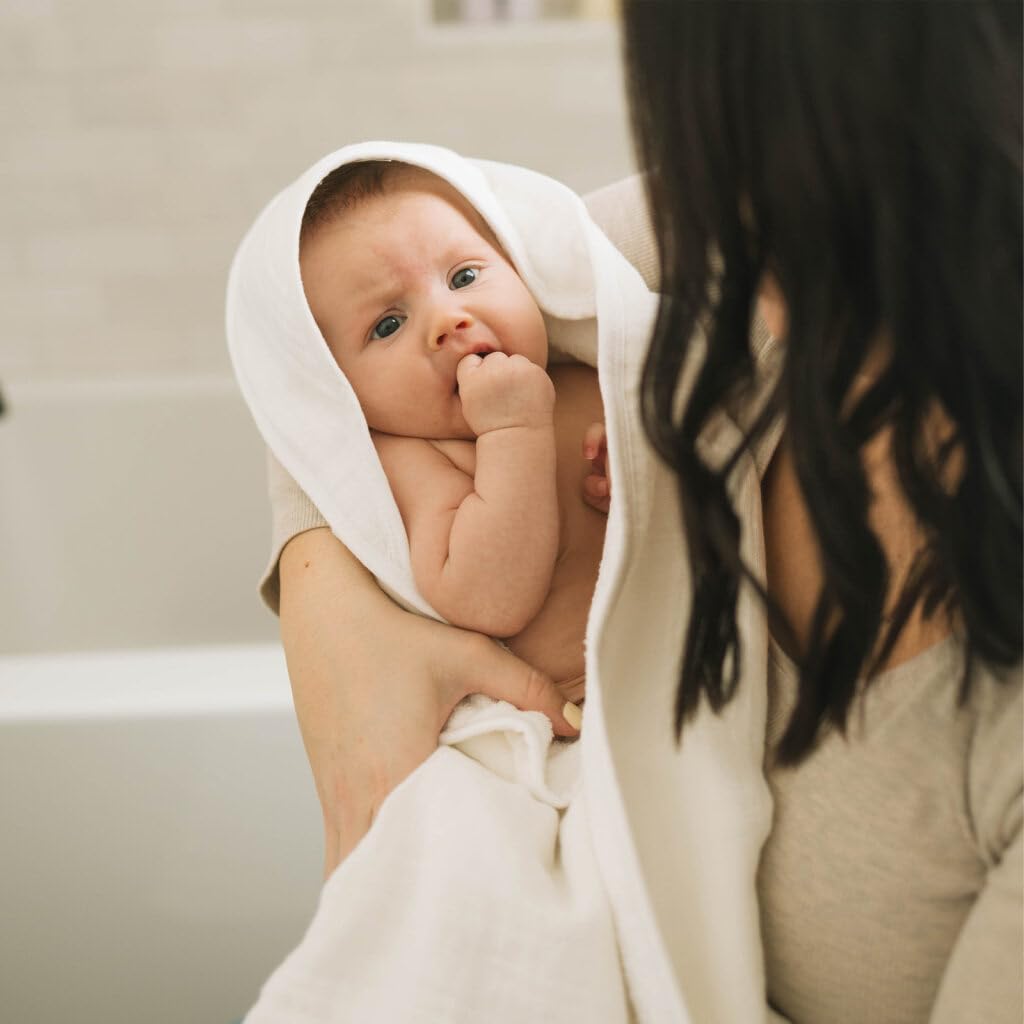 Baby wrapped in Little Unicorn hooded towel for cozy post-bath moment