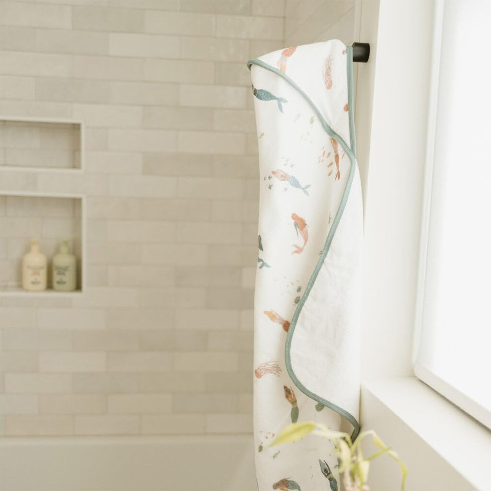 Little Unicorn mermaids muslin backing contrasts smooth exterior with colorful print.
