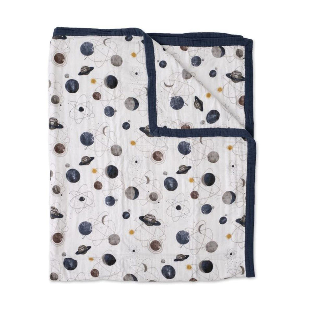 Little Unicorn Premium Quilted Throw Planetary folded, showing compact travel warmth for on-the-go families