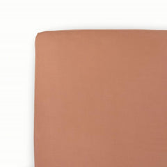 Little Unicorn premium stretch knit crib sheet in terracotta showing plush softness for baby sleep
