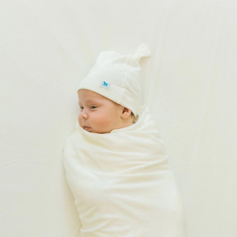 Little Unicorn premium stretch-knit crib sheet white dryer-safe care illustrates easy daily washing.