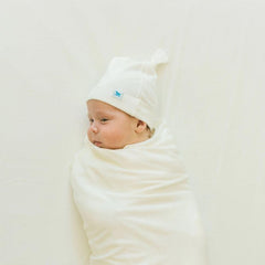 Little Unicorn premium stretch-knit crib sheet white dryer-safe care illustrates easy daily washing.