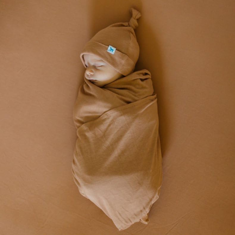 Little Unicorn terracotta stretch knit crib sheet on standard crib mattress demonstrating snug fit
