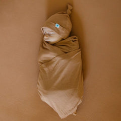 Little Unicorn terracotta stretch knit crib sheet on standard crib mattress demonstrating snug fit