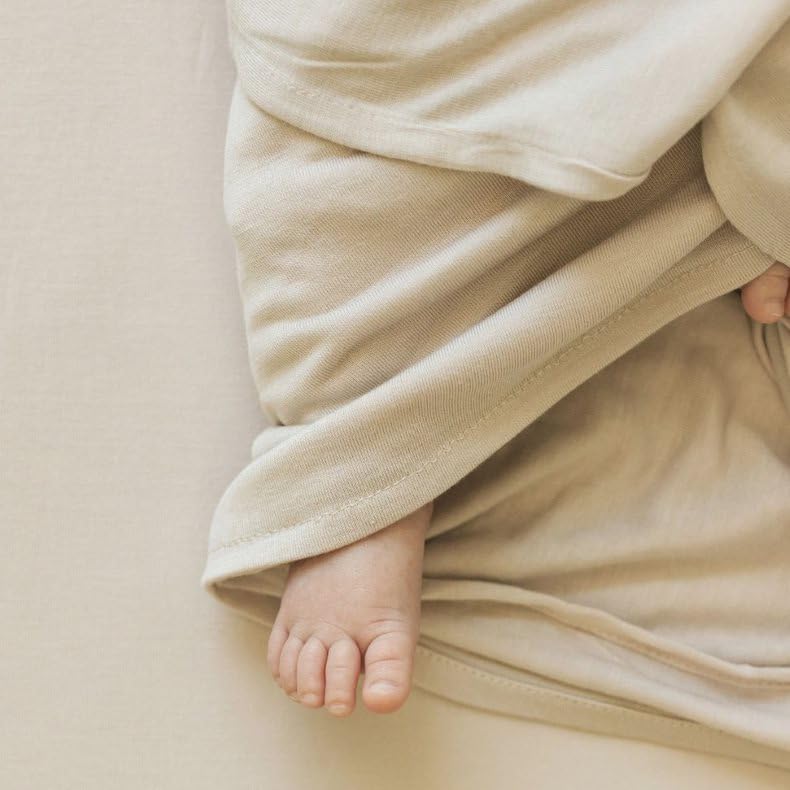 Little Unicorn swaddle blanket grey cross slips into a diaper bag.