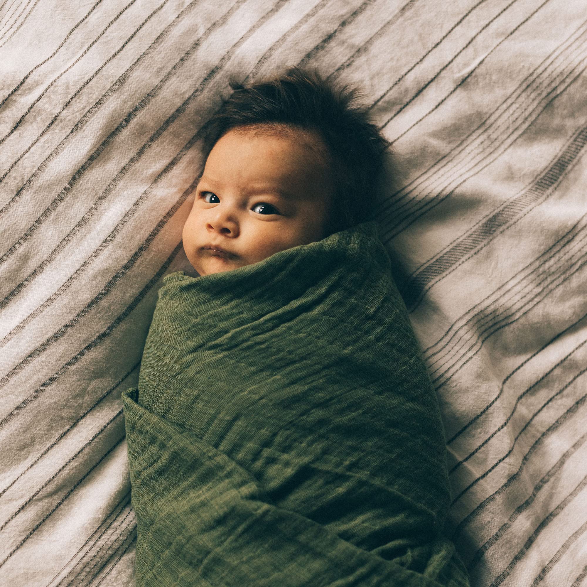 Little Unicorn Fern swaddle folded for travel; compact and portable.