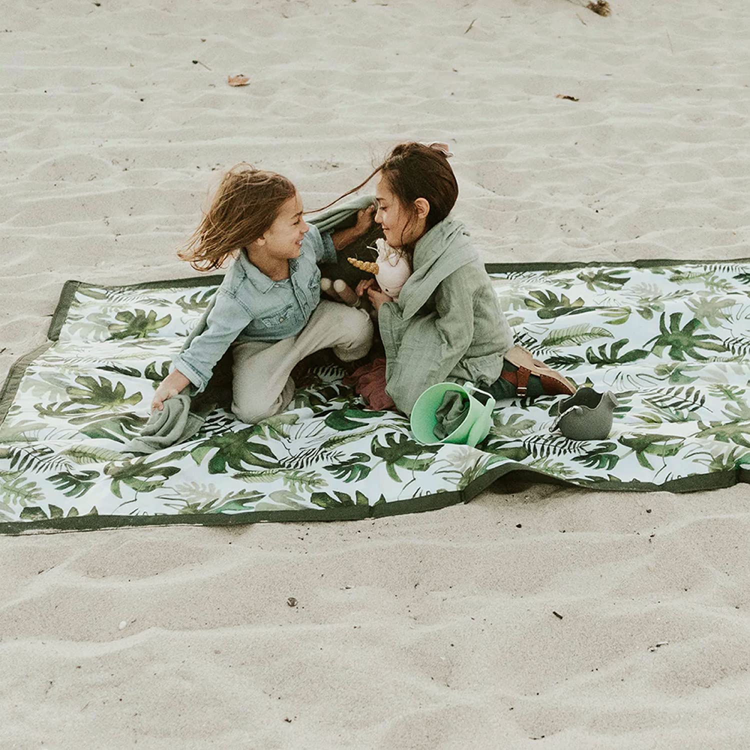 Little Unicorn tropical leaf blanket on sunny beach ready for family fun