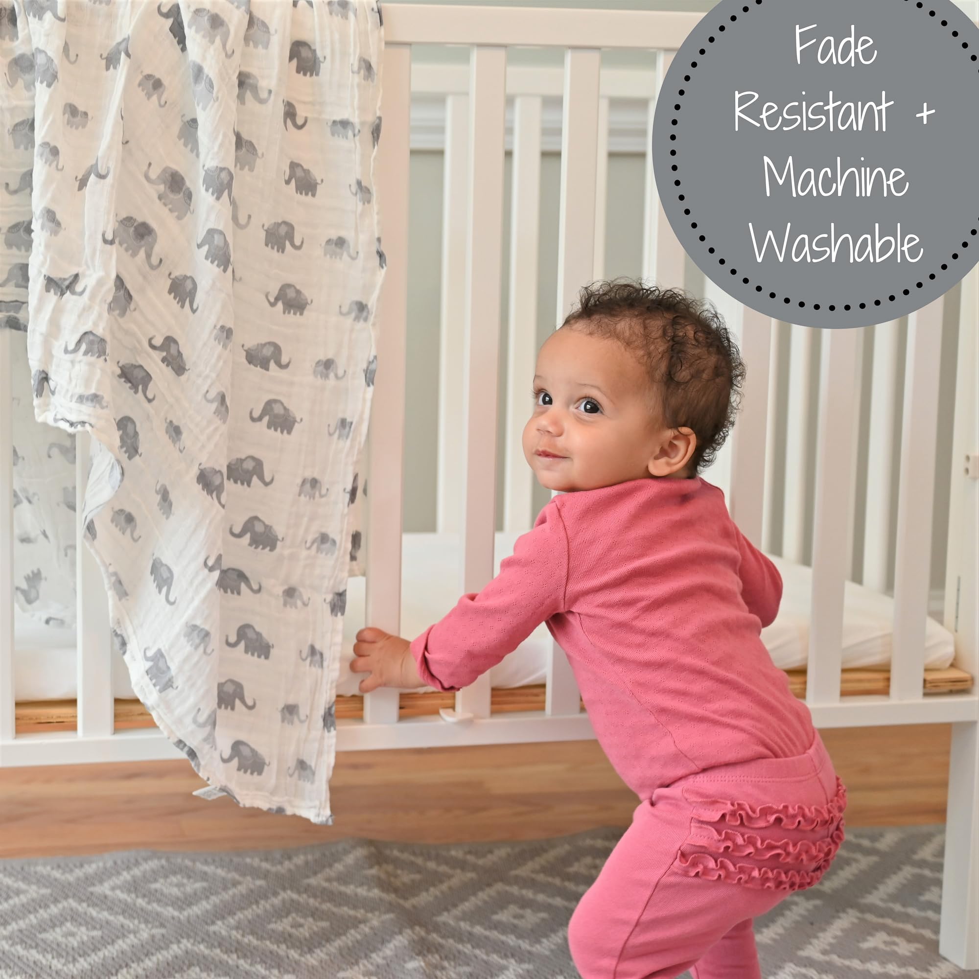 LollyBanks elephant print swaddle used as nursery decor on crib rail.