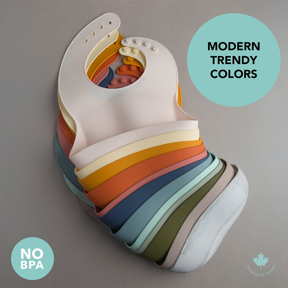 Loulou Lollipop bib Coconut Cream beside colorful foods for meal-time compatibility.