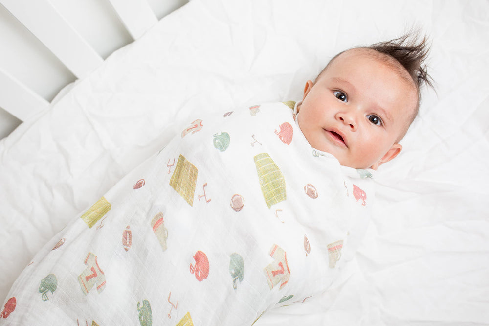 Lulujo football swaddle on baby demonstrates soft, breathable comfort.