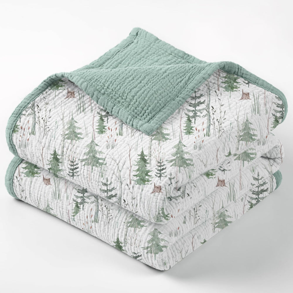 Lulumoon Muslin Blanket Green Forest Stump draped on crib for cozy sleep