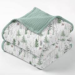 Lulumoon Muslin Blanket Green Forest Stump draped on crib for cozy sleep