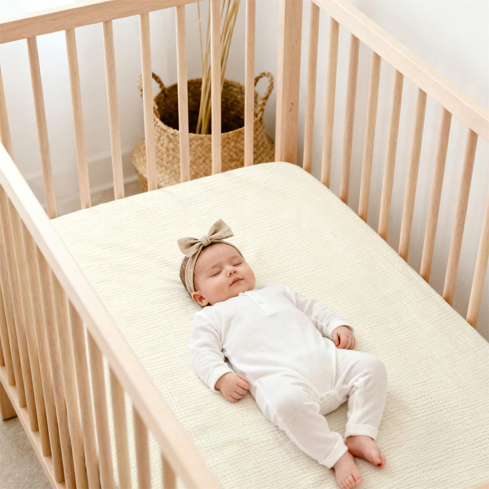 Lulu Moon muslin crib sheets fitted on a mattress demonstrating snug fit