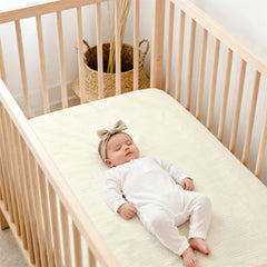 Lulu Moon muslin crib sheets fitted on a mattress demonstrating snug fit