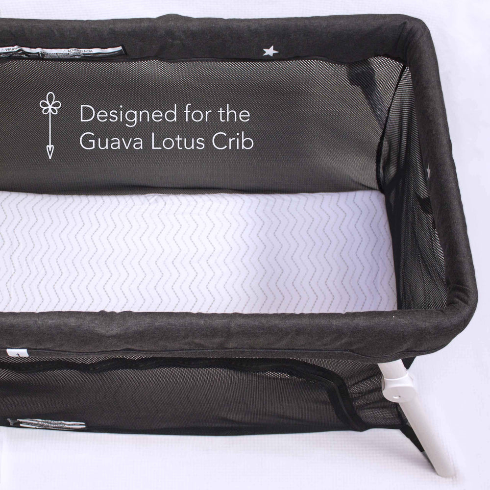 Luvberries Guava Lotus sheets on travel crib mattress provide secure fit and gentle comfort.