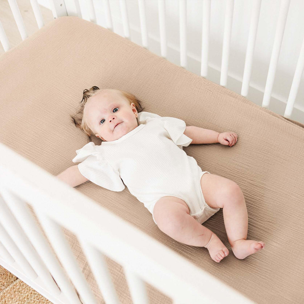 MairMore Muslin crib sheets in neutral ash and ivory complement nursery decor.
