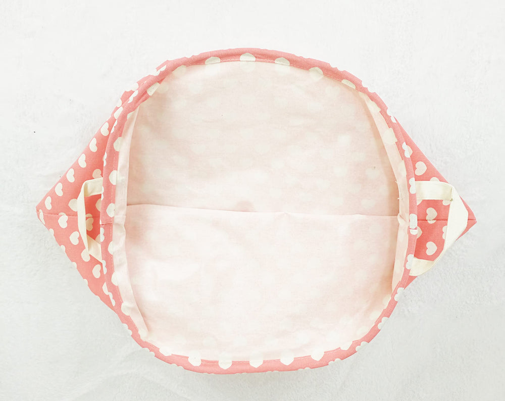 MAIZMZ pink hamper filled with clothes or toys demonstrates practical organization.