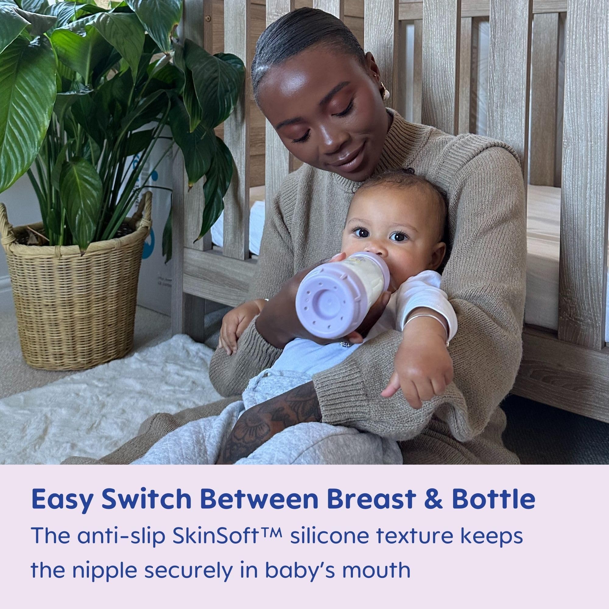 Baby grips a MAM bottle with an easy grip design
