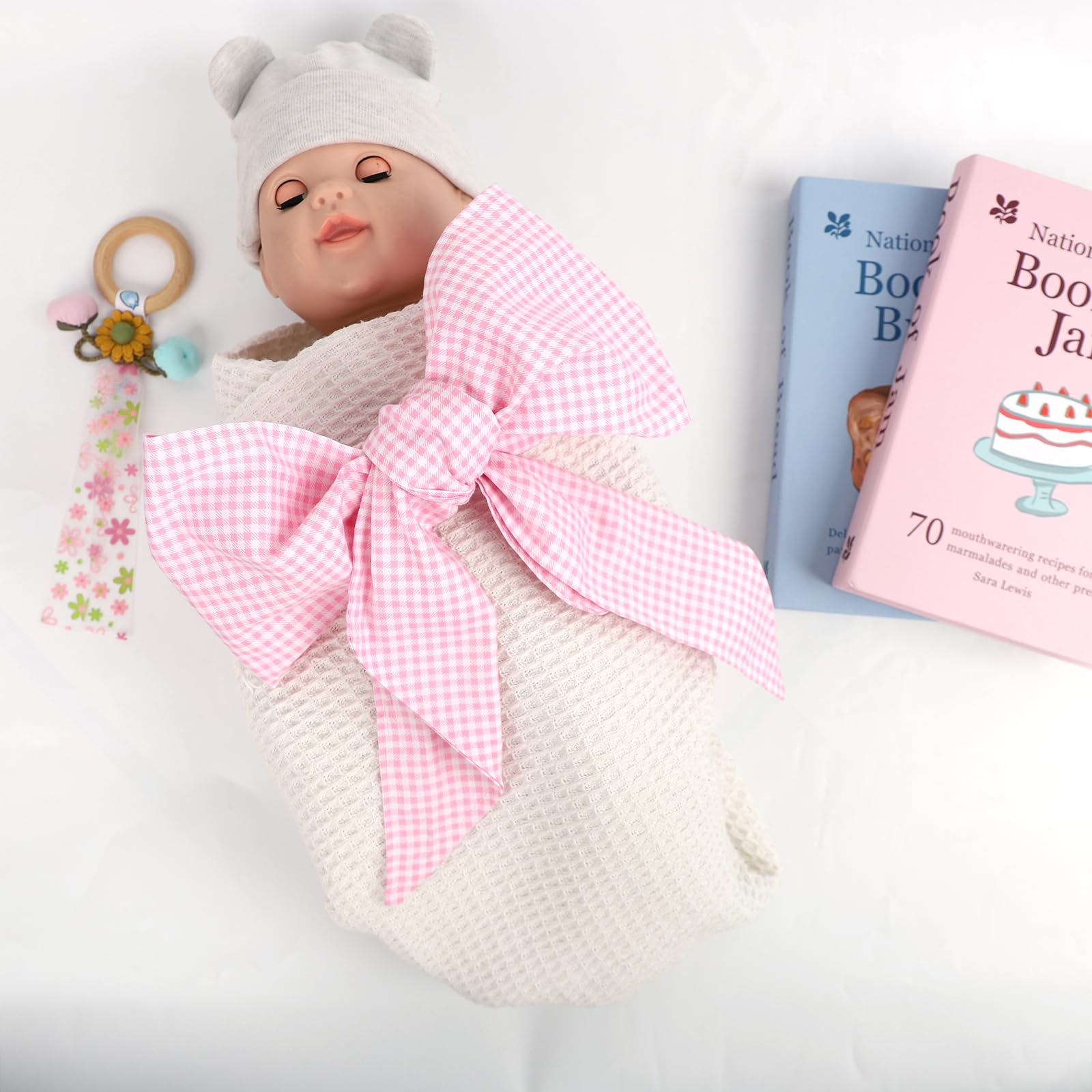 Man Fai Sky bowknot detail on newborn swaddle sash demonstrates delicate decoration for photos.