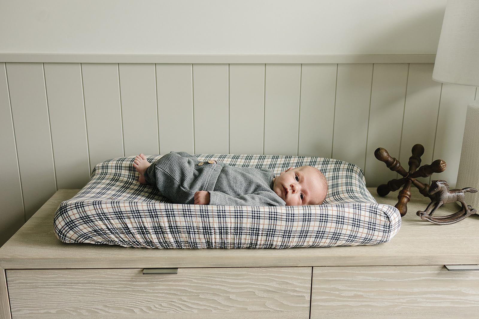 Mebie Baby vintage plaid pad cover styled with nursery decor and coordinating accents.
