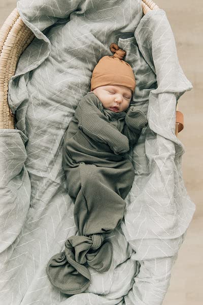 Mebie Baby wrapped in Desert Sage swaddle suggests secure, comfortable nighttime routine.