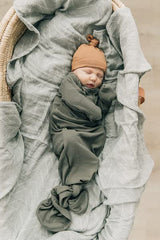 Mebie Baby wrapped in Desert Sage swaddle suggests secure, comfortable nighttime routine.