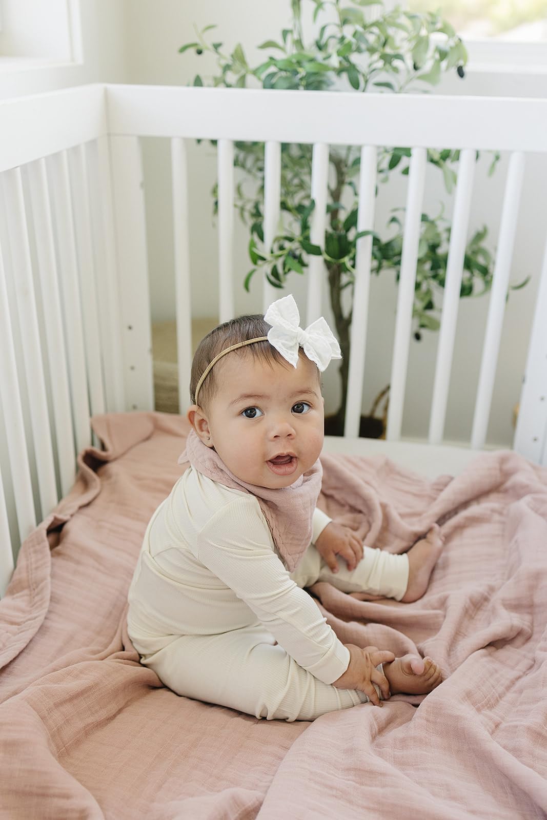 Mebie Baby muslin quilt dusty rose on crib offers breathable comfort for naps and playtime.