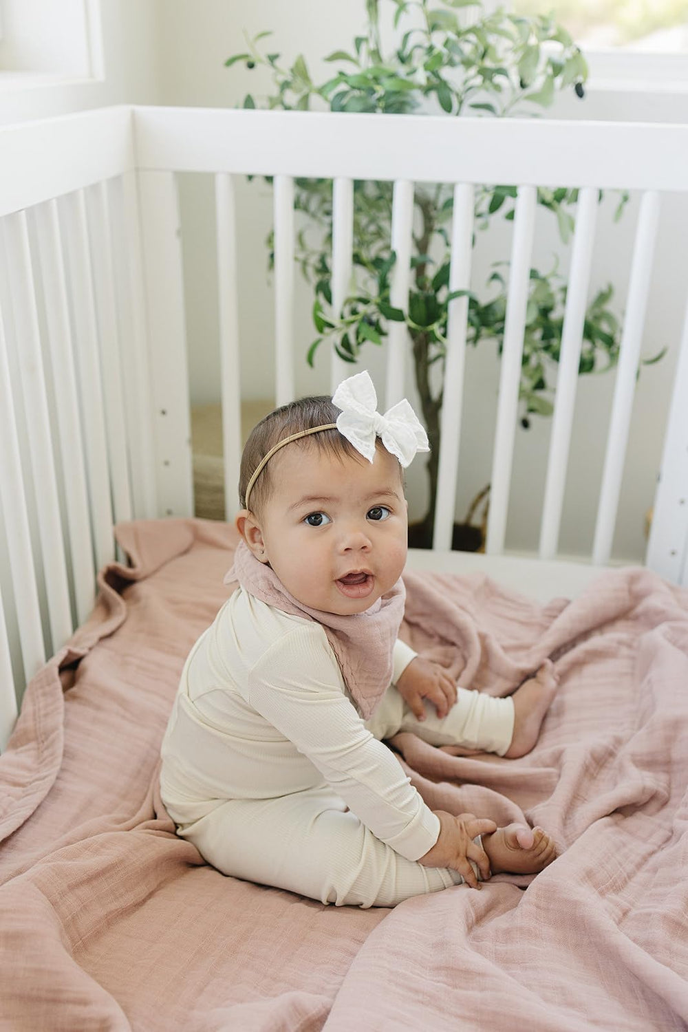 Mebie Baby muslin quilt dusty rose on crib offers breathable comfort for naps and playtime.