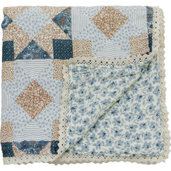 Mebie Baby muslin quilt patchwork print blue blossom shown as a cozy blanket.