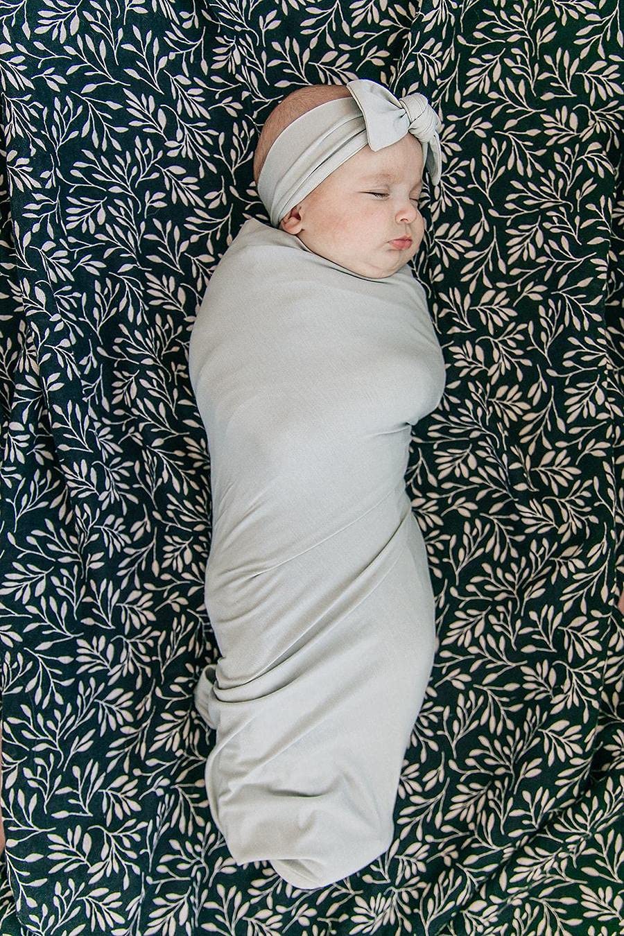 Mebie Baby Stone Swaddle in a nursery scene shows versatile styling options.
