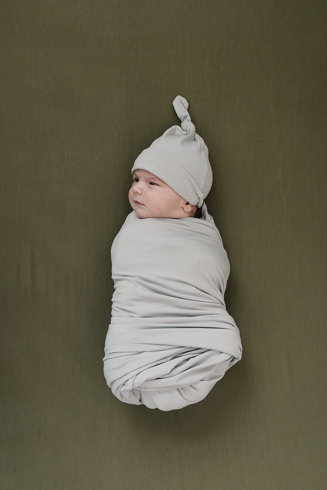 Mebie Baby Stretch Sheet Olive on mattress demonstrates snug 52x28 fit.