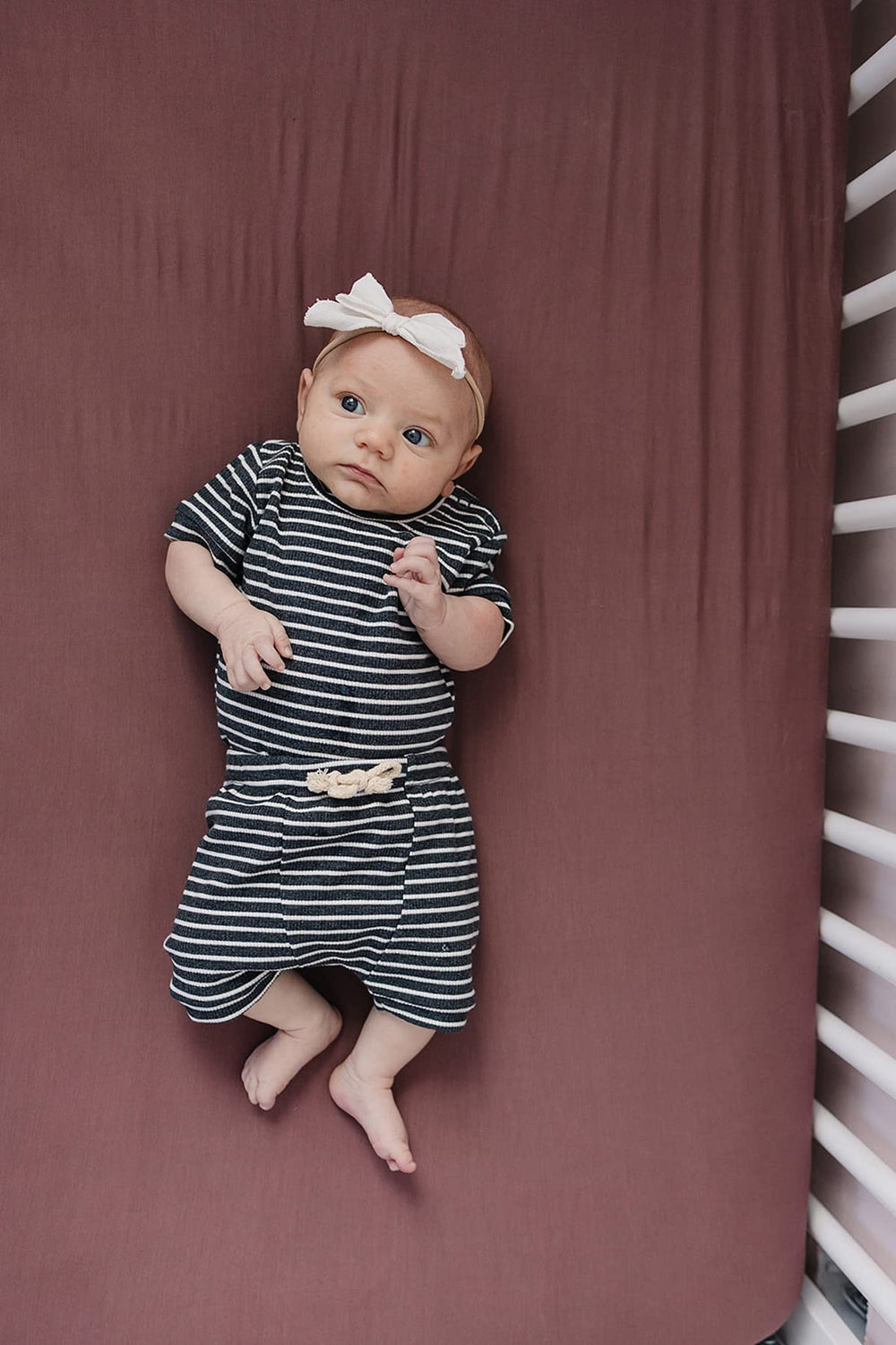 Mebie Baby Stretch Sheet Plum fitted edge demonstrates secure fit for easy nightly changes.