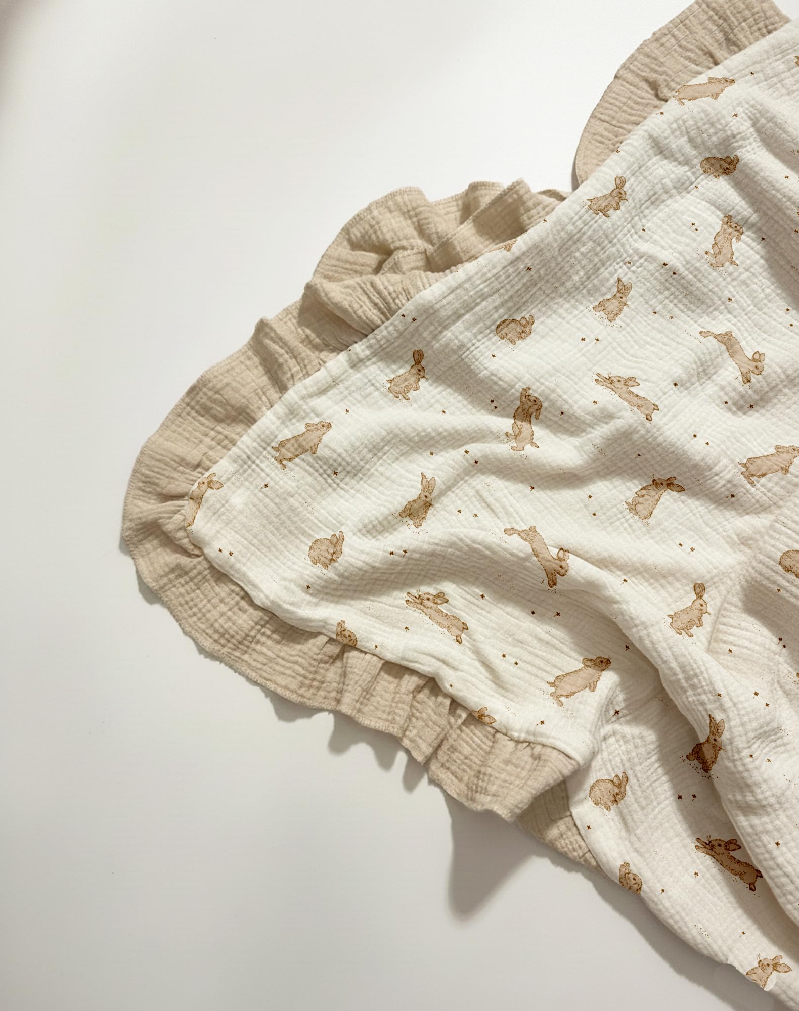 Meowcards Muslin Swaddle features ruffled-edge details for cozy naps.