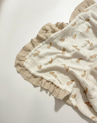 Meowcards Muslin Swaddle features ruffled-edge details for cozy naps.