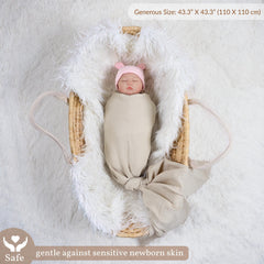 Meracorallo muslin swaddle being used to wrap a baby, highlighting soft fabric.
