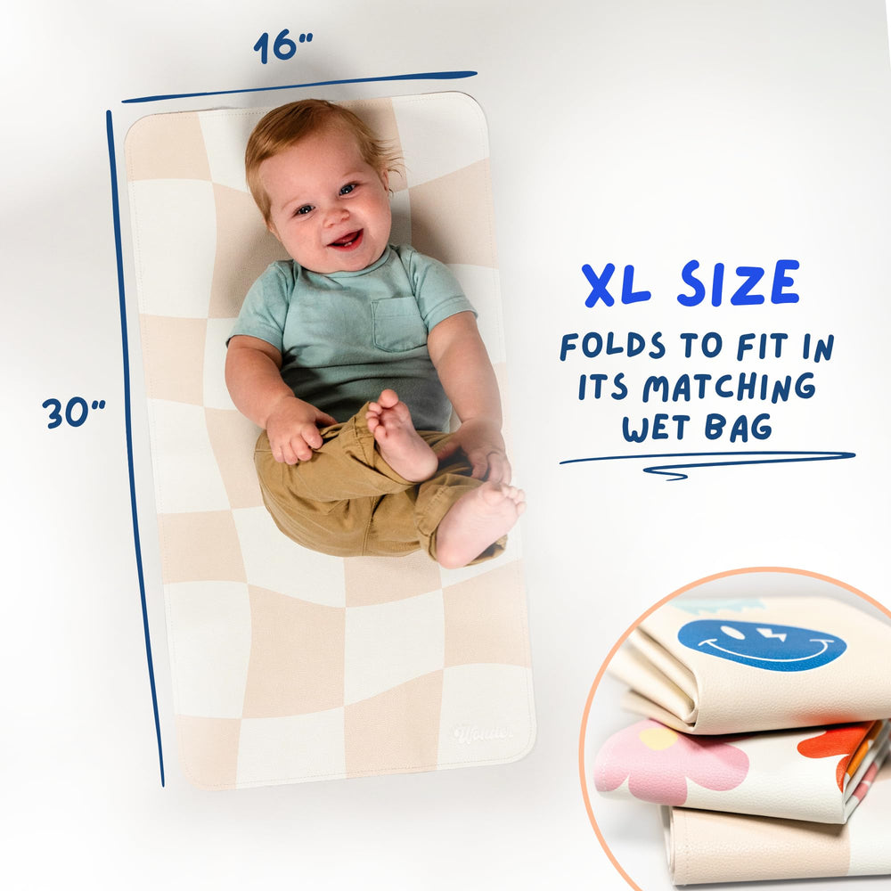 Miles of Wonder travel-ready changing mat beside a diaper bag.