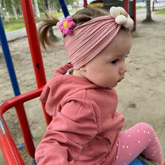 MIUXUESO pink flower headband worn by a baby, highlighting comfortable stretch
