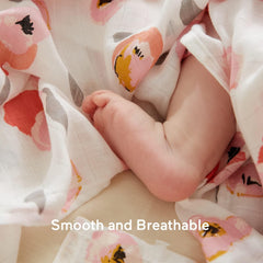 Momcozy muslin swaddle blanket wrapped around baby demonstrates secure cozy swaddling