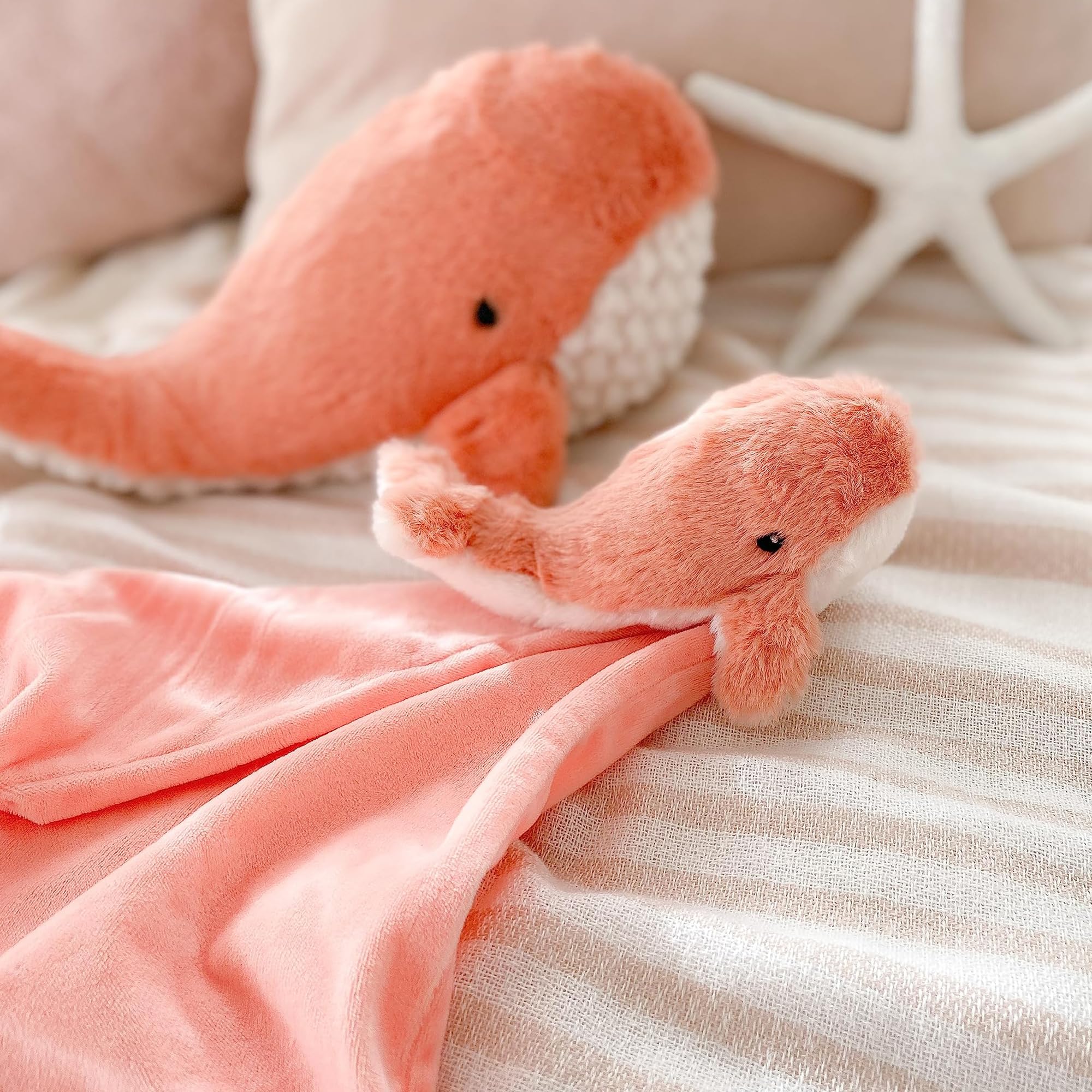 MON AMI Coral Whale Lovey on a crib proves a portable, soothing companion during car rides.