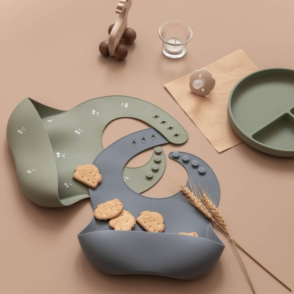 Moonkie bibs in use at mealtime catching spills and crumbs.
