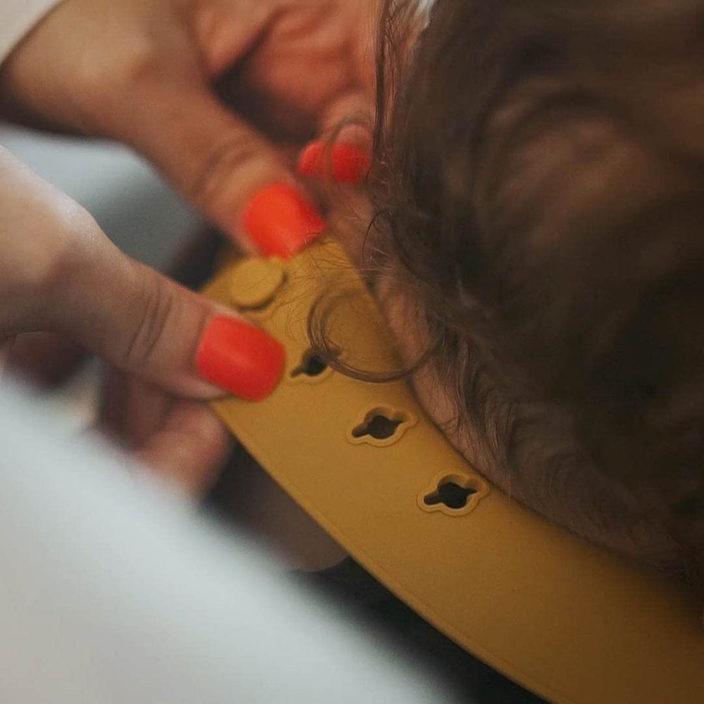 Moonkie 9x2 pocket bib — deep pocket catches spills and crumbs.