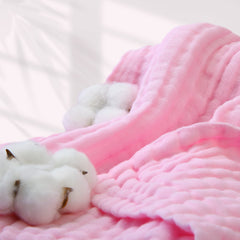 MUKIN swaddle blanket wrapped around sleeping baby demonstrating versatility.