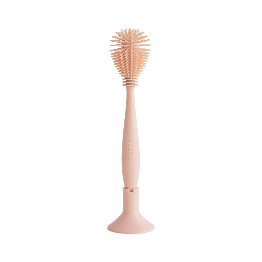 Mushie baby bottle brush with soft silicone bristles for gentle bottle cleaning.