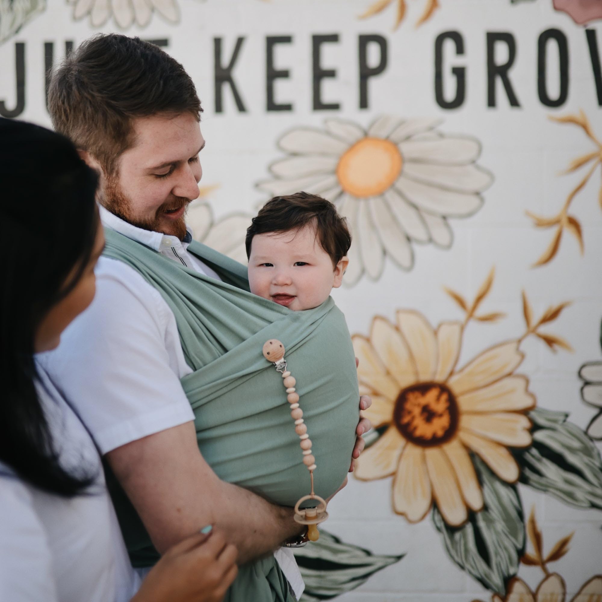 Mushie Baby Wrap Carrier worn by parent during a stroll for hands-free comfort