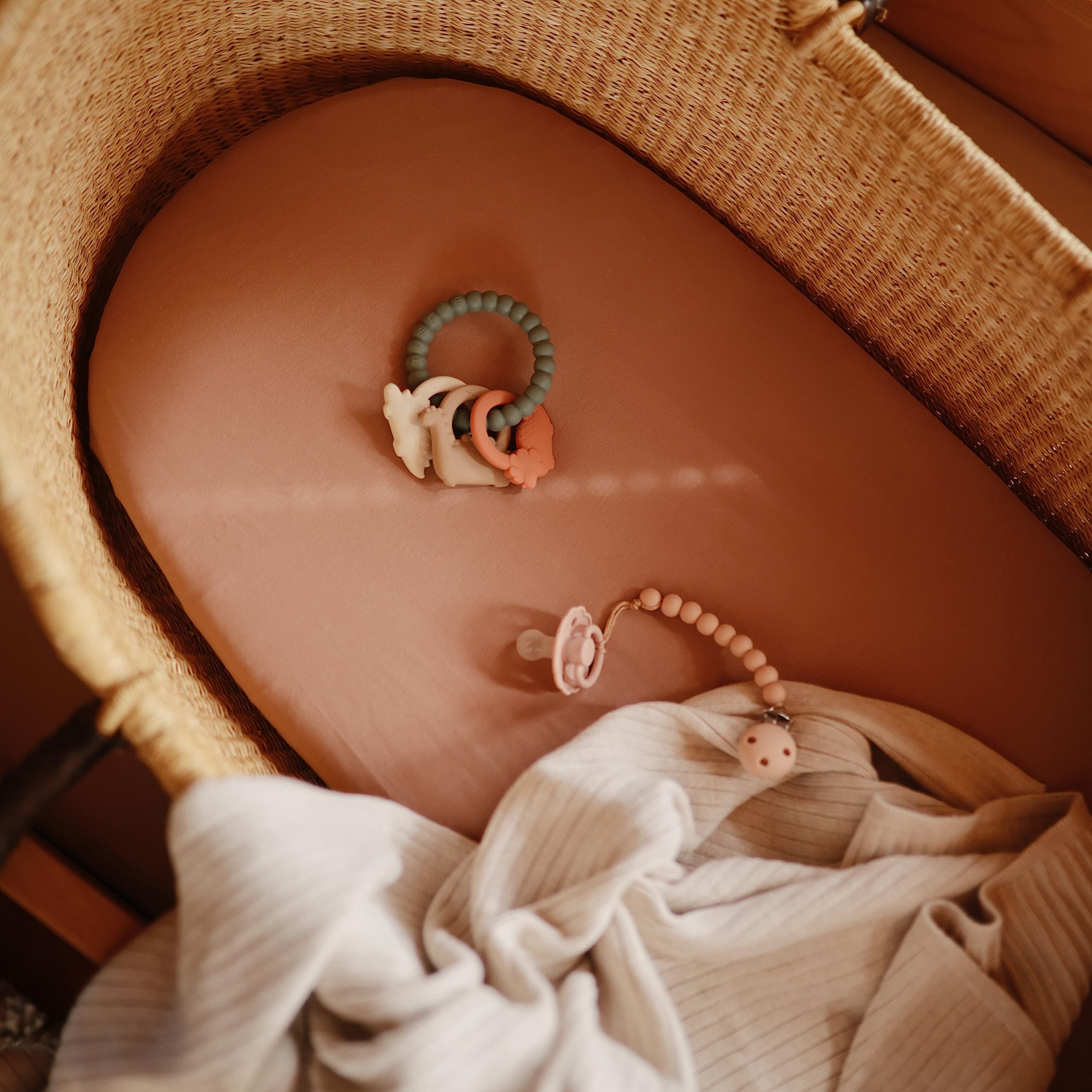 Mushie breathable fabric bassinet sheet Rainbows keeps baby warm without overheating.
