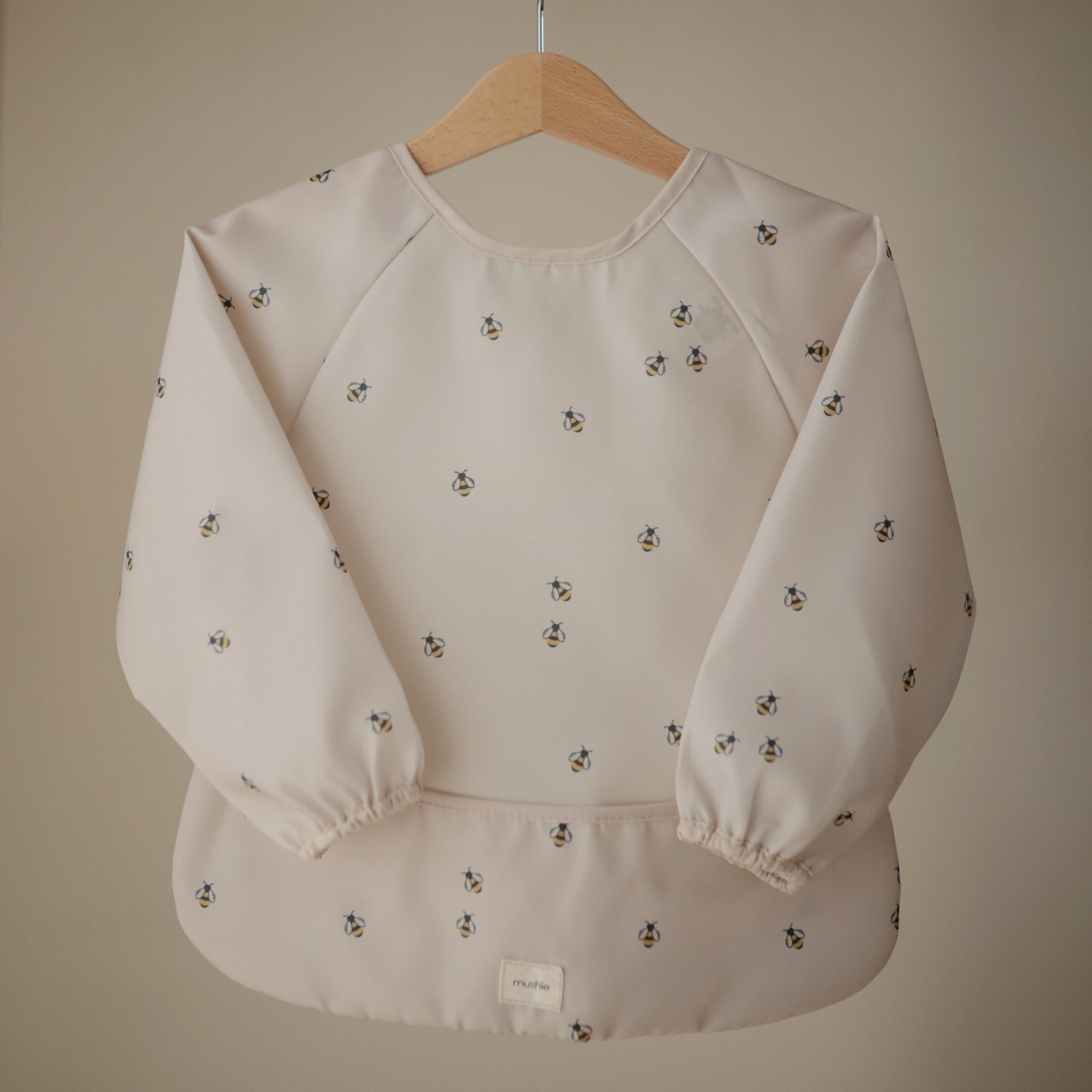 Mushie Bees long sleeve bib back view showing velcro neck closure for secure adjustable fit.