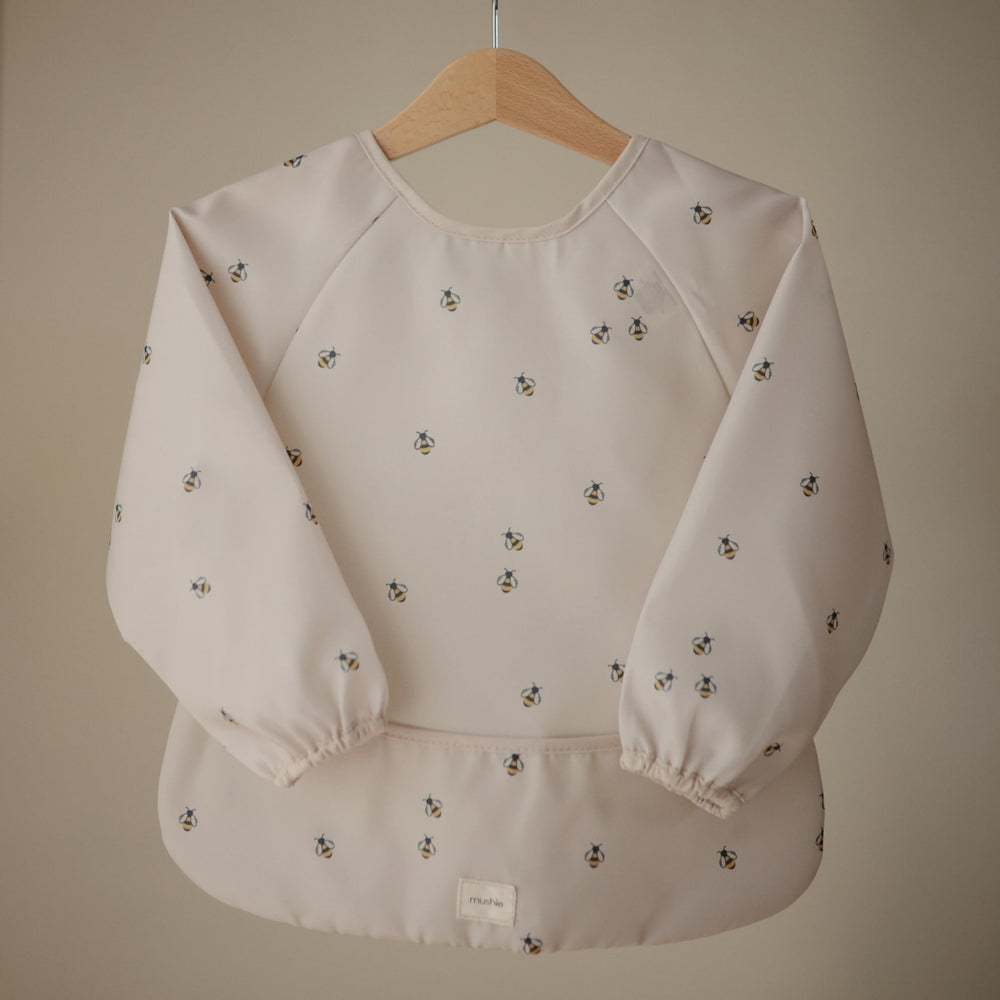 Mushie Bees long sleeve bib back view showing velcro neck closure for secure adjustable fit.