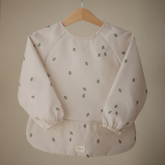 Mushie Bees long sleeve bib back view showing velcro neck closure for secure adjustable fit.