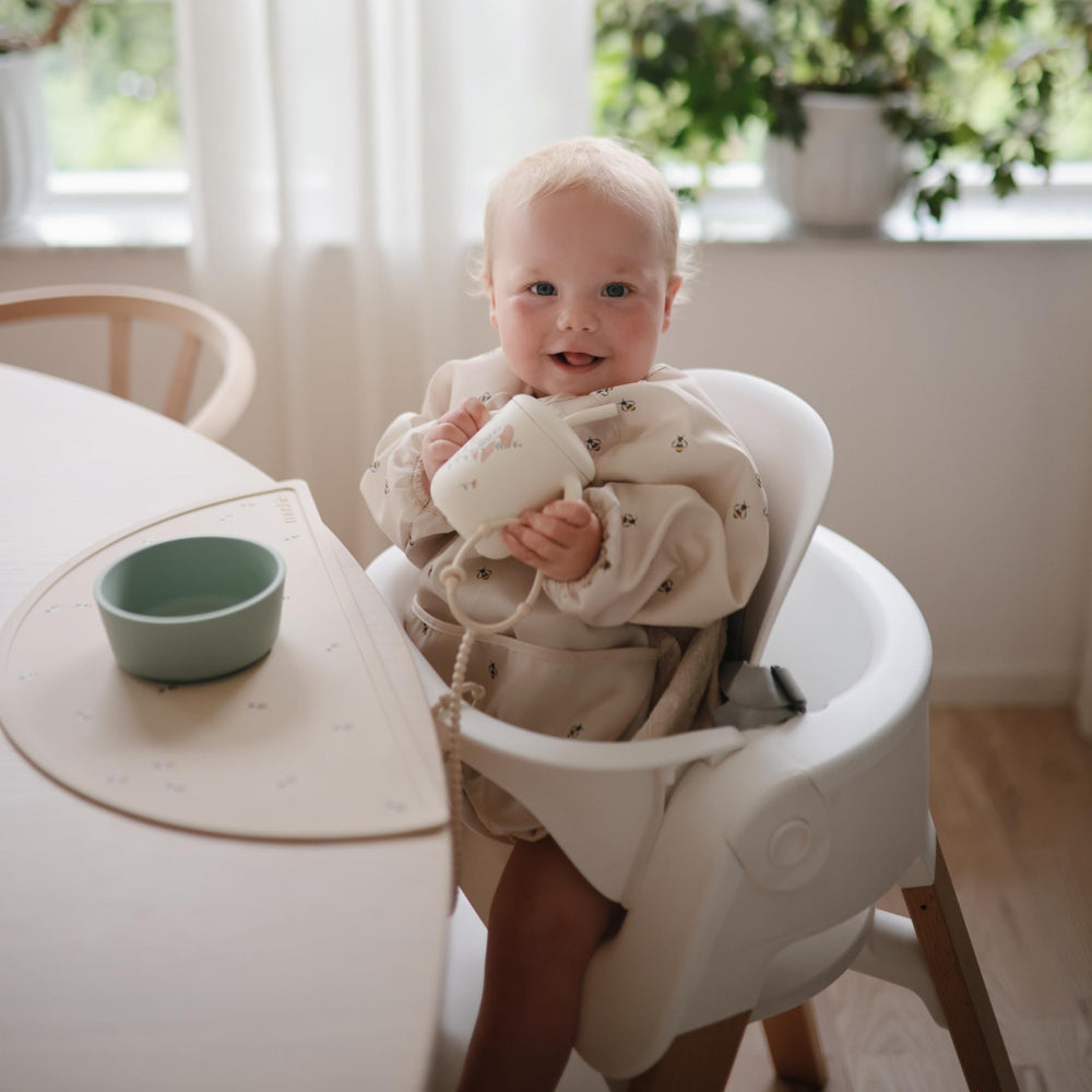 Mushie Bees long sleeve bib wipe-clean surface ideal for busy mealtimes.