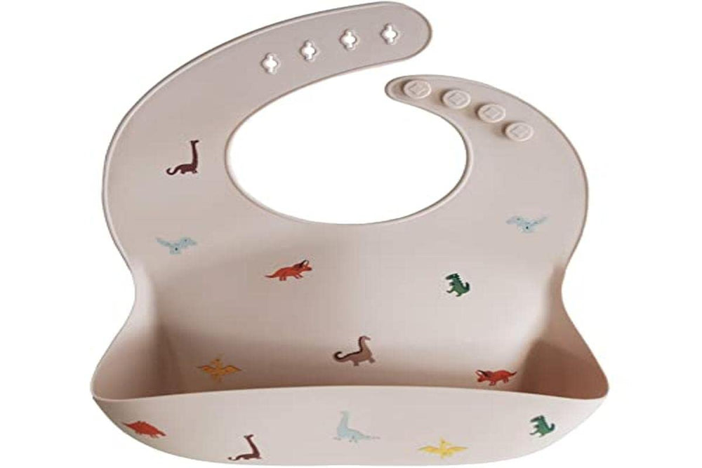 Mushie dinosaurs bib waterproof surface indicates spill-proof mealtime protection.